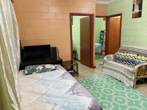 a living room with two beds and a television at Elizabeth Accomodation-Your Home Away from Home in Suva