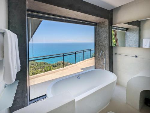 a white bath tub in a bathroom with a large window at Villa Moonshadow - Multiple Award Winning Villa in Chaweng Noi Beach