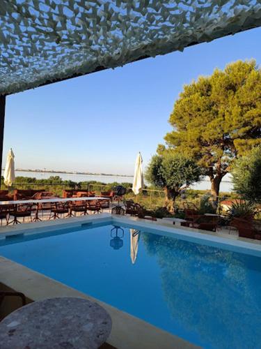 - une piscine avec des tables et des parasols dans un complexe dans l'établissement Le Lac des Rêves, à Lattes