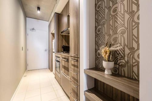 um corredor com uma cozinha com uma parede em Central Charm Small Studio Retreat in Melbourne em Melbourne