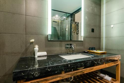 uma casa de banho com um lavatório e um espelho em Supu Hotel - Zhengzhou CBD International Convention and Exhibition Center em Zhengzhou