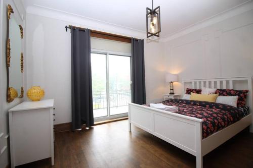 - une chambre avec un lit et une grande fenêtre dans l'établissement Charm & Luxury Vacation Headquarters to Downtown!, à Montréal