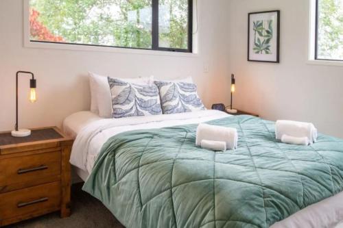 a bedroom with a large bed with two pillows at Central City-Urban Oasis 1 bed 1 bath w/sofa bed in Christchurch