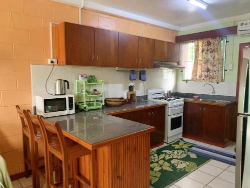 uma cozinha com armários de madeira e uma bancada em Elizabeth Accomodation-Your Home Away from Home em Suva