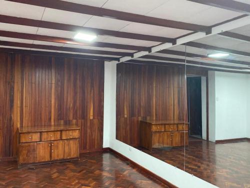 a room with wood paneled walls and wooden cabinets at CasaZheng in San José