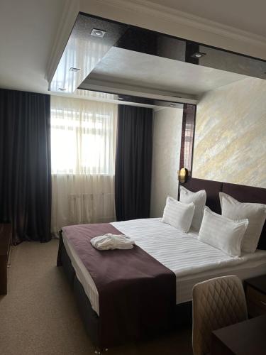a hotel room with a large bed in a room at Mereke Hotel in Ustʼ-Kamenogorsk