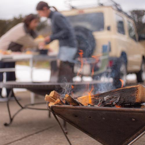 two people cooking food over a fire in a grill at 【飛騨高山】kiyomi荘-sou- 贅沢なプライベート空間 in Takayama