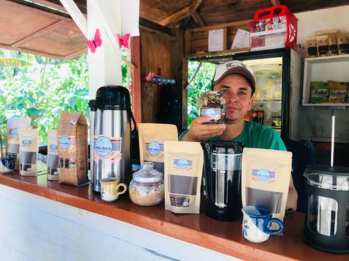 a man is sitting at a counter with a drink at Hostal Las Mariposas Minca in Minca