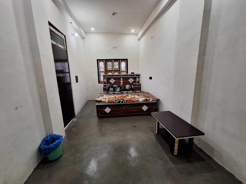 AyodhyaにあるHotel O Home Sita Ram Palaceのベッドとテーブルがある部屋