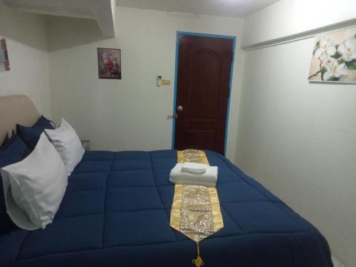 a bedroom with a blue bed and a door at Happy Home Guest House in Ban Phe