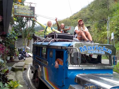 a group of people sitting on the top of a truck at Las vegas lodge and restaurant in Banaue