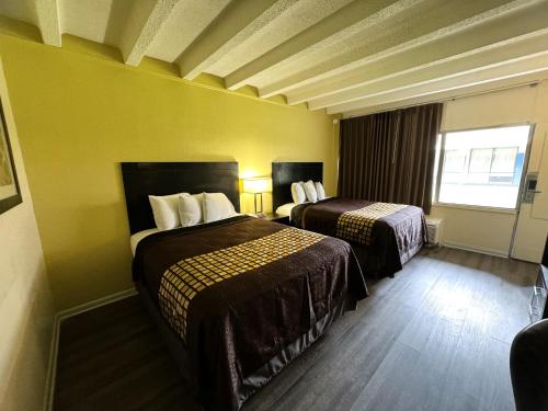 a hotel room with two beds and a window at James River Inn & Suites in Newport News