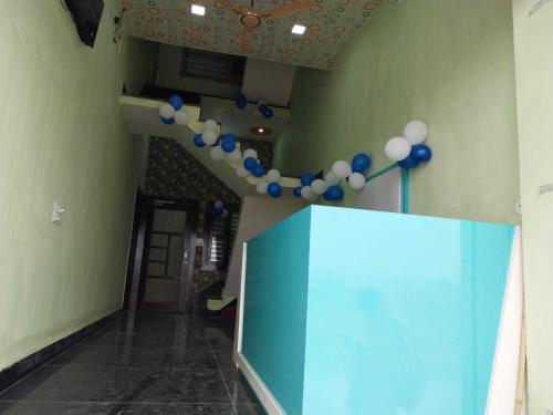 um corredor com balões azuis e brancos pendurados no tecto em OYO HOTEL GREEN em Jīnd