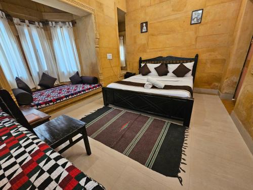 a bedroom with a bed and a couch in it at Hotel Royal Haveli in Jaisalmer