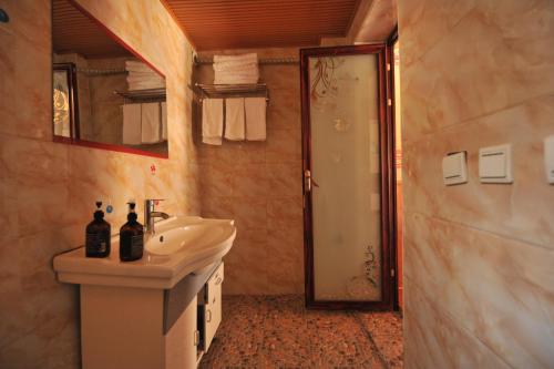 y baño con lavabo, espejo y ducha. en Tibet Guesthouse 虎跳峡卓玛客栈, en Shangri-La