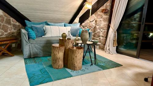 a living room with a couch and two tree stump tables at Château de feuilles in Baie Sainte Anne