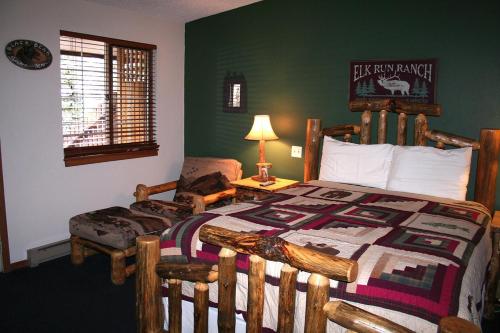 una camera con letto in legno e sedia di Timber Creek Chalets- 4 chalet a Estes Park