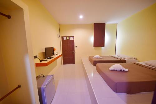 Cette chambre comprend deux lits et une télévision. dans l'établissement เคน อินน์ เพชรบุรี Kane Inn Petchaburi, à Tha Chang