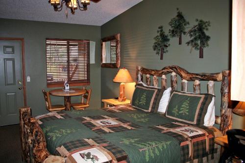 1 dormitorio con 1 cama y 1 mesa con lámpara en Timber Creek Chalets- 2A chalet en Estes Park