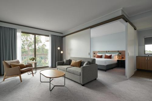 RACV Goldfields Resort في بالارات: غرفة معيشة مع أريكة وسرير