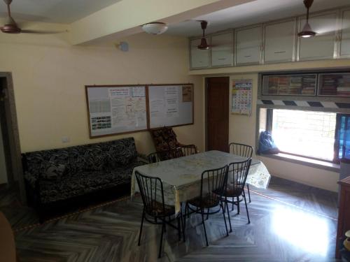 uma sala de jantar com uma mesa e cadeiras e um sofá em Govindaashram-Tarkarli em Bhogwe