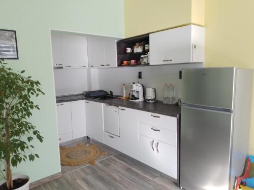 a kitchen with white cabinets and a refrigerator at Апартамент Рая 2 in Dobrich