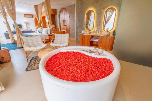 a bathroom with a tub filled with red flowers at Villa Kaliente in Nusa Penida