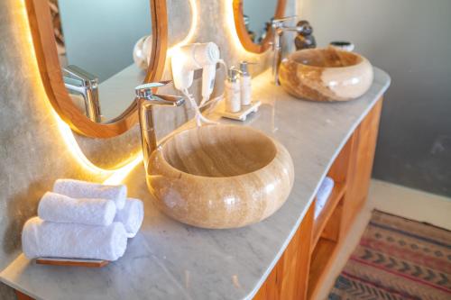 a bathroom counter with a sink and a mirror at Villa Kaliente in Nusa Penida