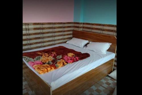 a bed with flowers on it in a room at Vivek Palace by StayApart in Barkot
