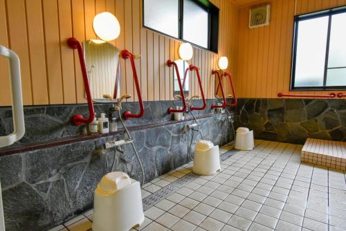 a bathroom with three urinals on the wall at Hotel Circle one in Hitoyoshi