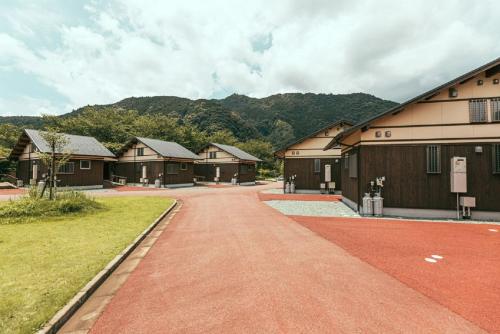 a row of buildings with a red dirt road at Hisetsu no Taki Campsite - Camp - Vacation STAY 42072v in Ōzato