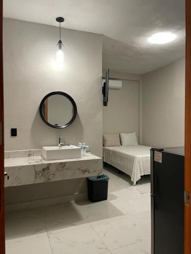 baño con lavabo, espejo y cama en Posadas LUZ DE MAR, en Dzilam de Bravo
