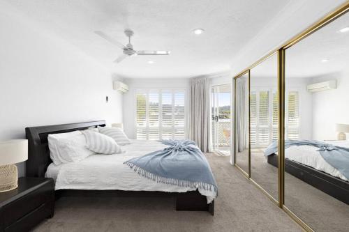a bedroom with a bed and a large mirror at 64 Isle of Palms in Gold Coast