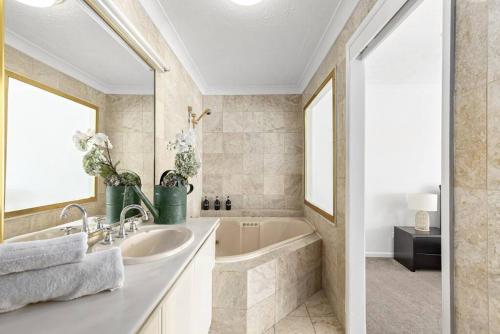 uma casa de banho com uma banheira e um lavatório em 64 Isle of Palms em Gold Coast