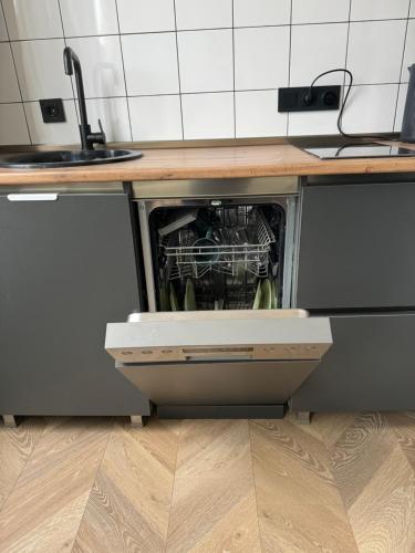 a dishwasher with its door open in a kitchen at Aparthotel Old Avenue in Tbilisi City