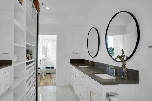 a white bathroom with a sink and a mirror at Luxury hilltop retreat, majestic views and hot tub in Los Angeles