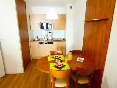 a small kitchen with a dining room table with a yellow table cloth at Résidence Pic Du Midi - Apt n°143 - 1er étage - Bâtiment Hourquette MAE-8644 in La Mongie