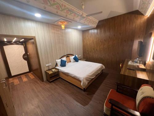 a bedroom with a bed and a desk and a tv at hotel babu heritage in Bikaner