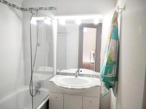 ein weißes Bad mit einem Waschbecken und einer Dusche in der Unterkunft Résidence Pic Du Midi - 3 Pièces pour 7 Personnes 614 in La Mongie
