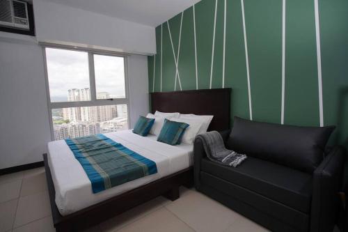 1 dormitorio pequeño con 1 cama y 1 sofá en Simple Ortigas Suite w/ City View, & Pool 3017 en Manila