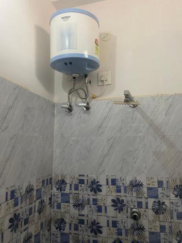 a bathroom with a shower with a fan on the wall at Hotel moon light in Rājgīr