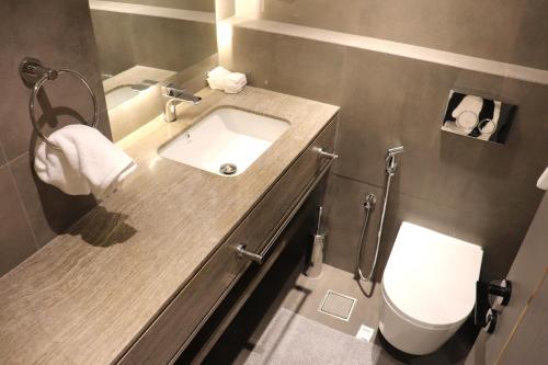 a bathroom with a sink and a toilet at Liyaqat Airport Residence in Muscat