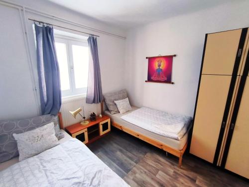 a small bedroom with two beds and a window at Caesar Residence in Budapest