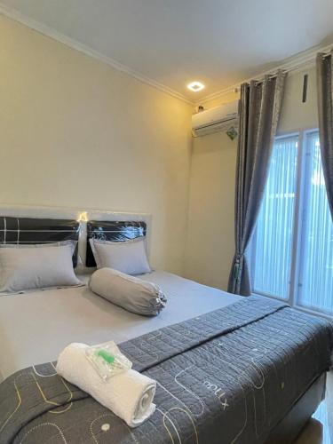 Tempat tidur dalam kamar di Farastha Homestay