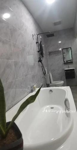 a bathroom with a white sink and a potted plant at Homestay with pool kuantan in Kuantan