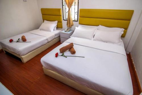 Un pat sau paturi într-o cameră la Rose Cottage Hotel Bandar Seri Alam