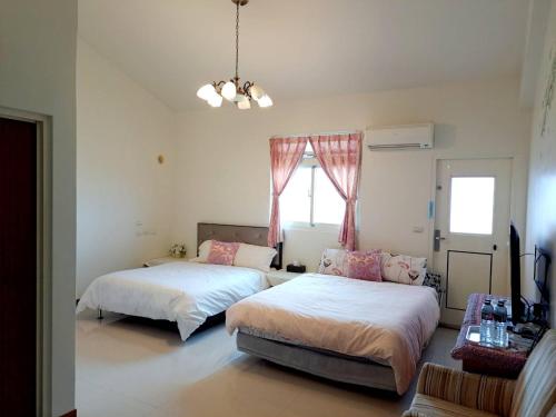 a bedroom with two beds and a window at Pure Farm B&B No0856 in Zhuangwei