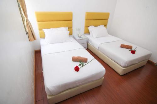 Un pat sau paturi într-o cameră la Rose Cottage Hotel Bandar Seri Alam