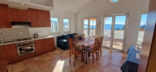 a kitchen and dining room with a table and chairs at Villa Annidia Komiza in Komiža