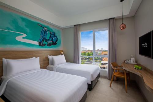 A bed or beds in a room at favehotel Sidoarjo